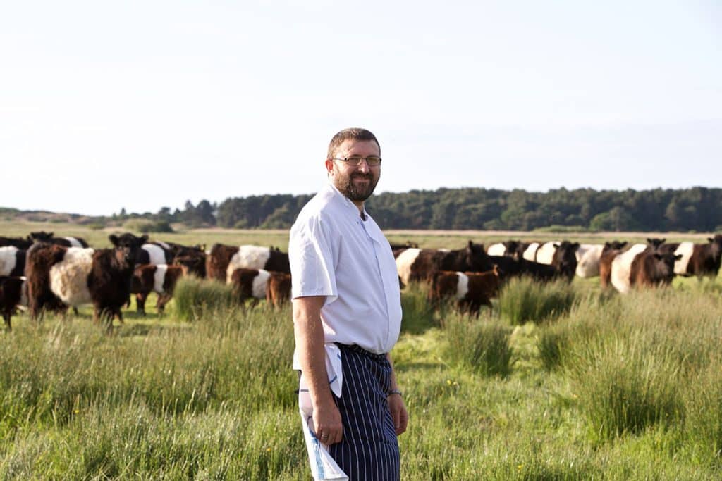 The Victoria's Head Chef, Michael Chamberlain, on the Holkham National Nature Reserve with some Belted Galloway cattle.