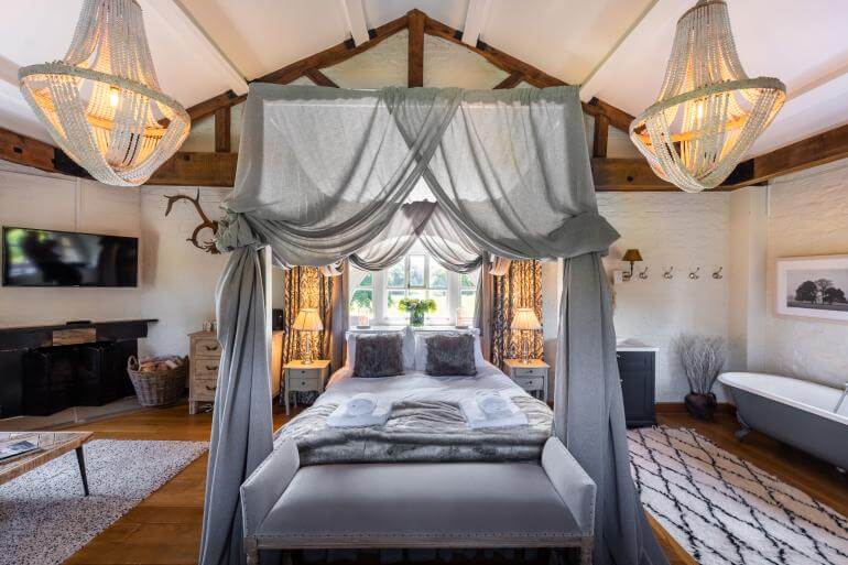 A grand four poster bed with drapes.